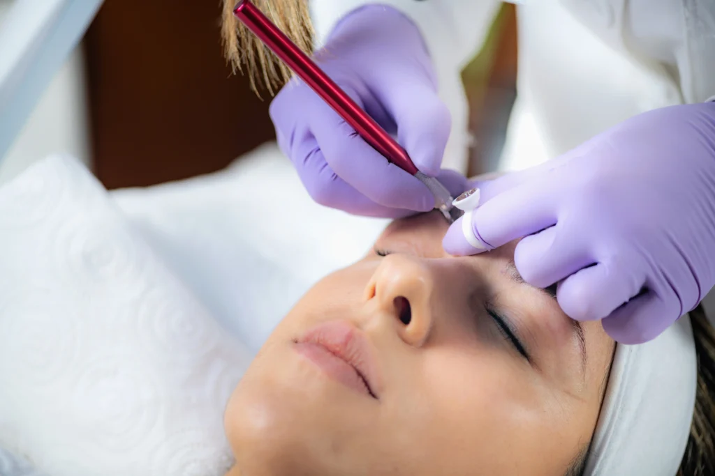 Esteticista haciendo micropigmentación en cejas