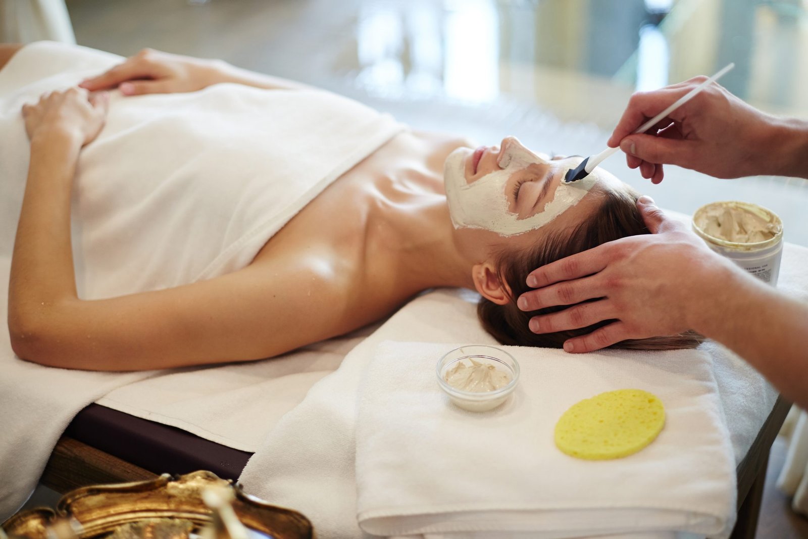 Mujer tumbada en camilla con mascarilla facial