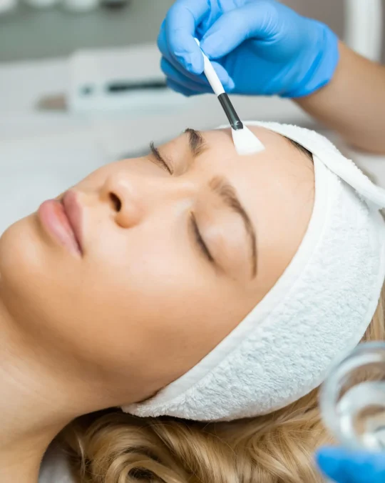 Esteticista aplicando mascarilla facial